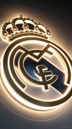 the real madrid crest is illuminated in gold and white with crown on top, surrounded by glowing lights