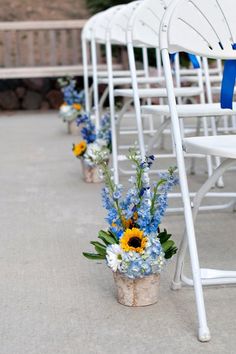 rows of white chairs with blue and yellow flowers