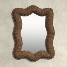 a mirror that is made out of rope and has a brown frame on the wall