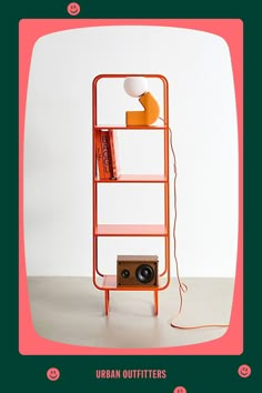 an orange book shelf with books on it and a small camera in front of it