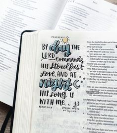 an open bible with hand lettering on it