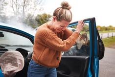 a woman is getting out of her car