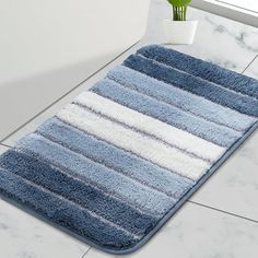 a blue and white rug on the floor next to a potted plant