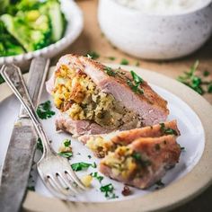 a white plate topped with meat and vegetables next to a bowl of broccoli