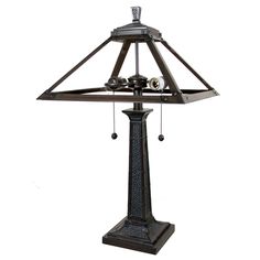 a lamp that is sitting on top of a wooden stand with bells hanging from it's sides