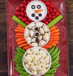 a plate with carrots, cauliflower, celery and other vegetables arranged in the shape of a snowman