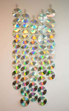 a white wall with lots of cds hanging from it's sides and two pairs of earrings on each side