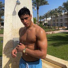 a shirtless man standing in front of a fountain