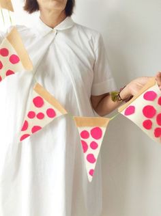 a woman holding two pieces of paper with polka dots on them and one piece has been cut out