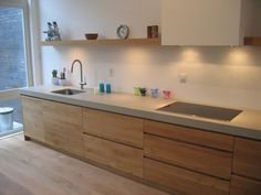 a kitchen with wooden cabinets and white counter tops next to a large glass doored window