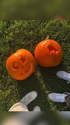 three carved pumpkins sitting in the grass with their faces carved like jack - o'- lanterns