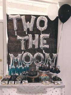 two the moon balloons and desserts on a table in front of a sign that says two the moon