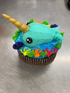 a cupcake with blue frosting and a unicorn horn on top