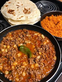 two pans filled with food sitting on top of a stove next to each other