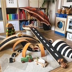 a child's room with toys and bookshelves on the floor, including an open umbrella