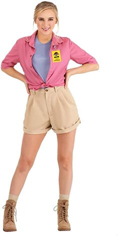 a woman in pink shirt and tan shorts standing with her hands on her hipss