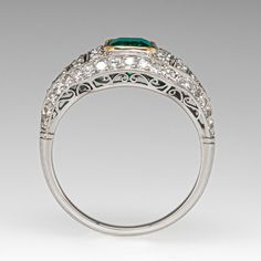 This gorgeous ring is centered with an emerald cut emerald, weighing 1.00 carat, in a yellow gold plated bezel. The top of the ring is bead set with fifty-eight (58) round single cut diamonds and accented with milgrain details. The ring measures 9.9mm at the top, rises 4.8mm above the finger, tapering to 1.7mm wide and 1.1mm thick at the base of the shank. It is currently a size 6.5. The emerald is unnoticeably chipped. Art Deco Oval Emerald Ring With Brilliant Cut, Heirloom Emerald Diamond Ring For Formal Events, Formal Bezel-set Baguette-cut Emerald Ring, Exquisite Emerald Baguette Cut Ring, Formal Baguette Cut Emerald Ring With Bezel Setting, Luxury Emerald Cut Emerald Ring In White Gold, Exquisite Emerald Cut Yellow Gold Emerald Ring, Elegant Emerald Cut Ring With Bezel Setting, Elegant Asscher Cut Ring With Bezel Setting