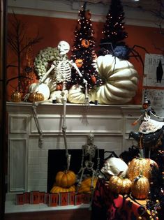 an image of a living room with pumpkins on the mantel and skeleton decorations