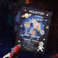 a baby shower card with an image of a rocket ship and planets in the background