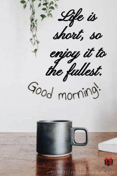 a coffee mug sitting on top of a table next to a wall with a quote saying life is short, so enjoy it to the fullest