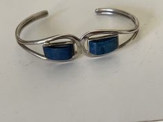 "Beautiful designer bracelet with large fantasy cut cabochon blue stones styled into a cuff bracelet created in sterling silver. This bracelet will fit a 6.5\" wrist and sizes close to that. The large blue stones are bezel set and have a deep blue color. This cuff style bracelet is hallmarked with the designers initials DS ??? Can't really make out last three initials." Designer Bracelet, Blue Stones, Cabochons Stones, Sterling Silver Cuff, Silver Cuff, 14kt Gold, Blue Stone, Bracelet Designs, White Gold Diamonds