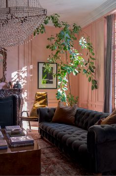 a living room filled with furniture and a chandelier hanging from the ceiling next to a window