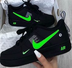 someone is holding their black and green nike air force 1s in their hand,