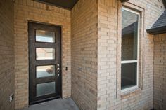 a brick building with a black door and window