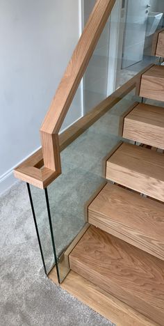 a wooden stair case with glass handrails