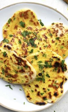 three quesadillas on a white plate with parsley