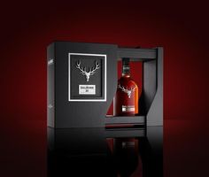 a bottle of whisky in a black box with a red background and a deer's head on the label