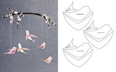 paper birds hanging from a branch with flowers in the middle and on top of it