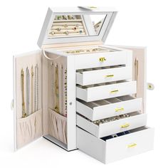 a white jewelry box with five drawers and gold necklaces in the top drawer open