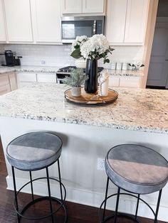 two stools sit at the center of a kitchen island