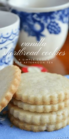 cookies are stacked on top of each other in front of cups and saucer bowls