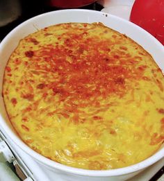 a white bowl filled with cheese on top of a stove