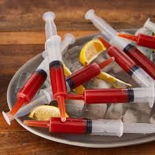 a plate filled with lemons and syringes on top of ice cubes