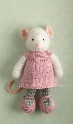 a small stuffed animal with pink dress and boots on it's feet hanging from a wall