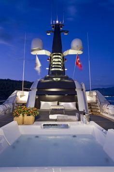 the jacuzzi is on top of the boat at night with its lights on