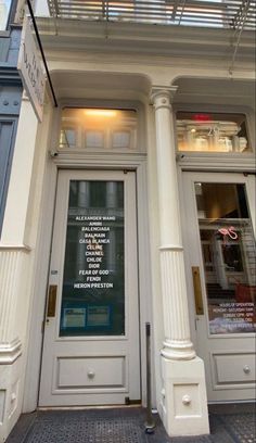 the front entrance to a store with an awning over it's door and windows