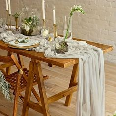 a wooden table topped with plates and candles