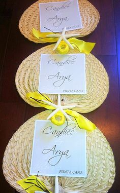 three wicker baskets with yellow ribbons and place cards on them for guests to sign