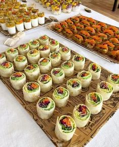 a table topped with lots of different types of food on top of a white table cloth