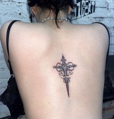 a cross tattoo on the back of a woman