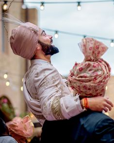 a man with a turban on his head is holding a woman's head