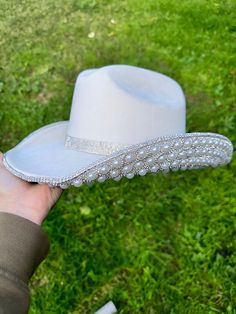 this one is made for the cowgirl bachelorettes that want a touch of class  ivory cowgirl hat with pearls and rhinestones on the bottom brim  This is one size fits most, there's a drawstring to adjust sizing.  ships in 2 business days! Stunning in person  Perfect for Halloween , Barbie costume, Coachella , stagecoach, Nashville, country concerts, bachelorette parties, brides, weddings Please note that the hats are handmade and may have some variances and blemishes. If any, they are very minor . T Western Hat Bands For Wedding And Kentucky Derby, Western Wide Brim Wedding Hat, Western Style Fitted Wedding Hat, Western Wedding Hat With Rhinestones, Halloween Barbie Costume, Rhinestone Cowgirl Hat, Hat With Pearls, Vegas Photoshoot, Halloween Barbie