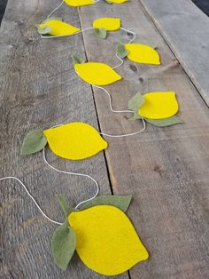 some yellow flowers are sitting on a wooden table with string attached to the stems and leaves