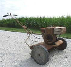 an old rusty lawn mower sitting on gravel