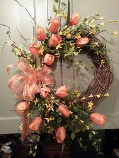 a wreath with pink flowers and green leaves