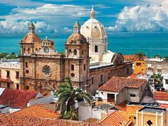 an aerial view of the old city with its cathedrals and rooftops, overlooking the ocean